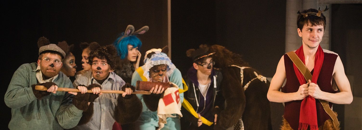 Students on stage in play, with several dressed as rodents