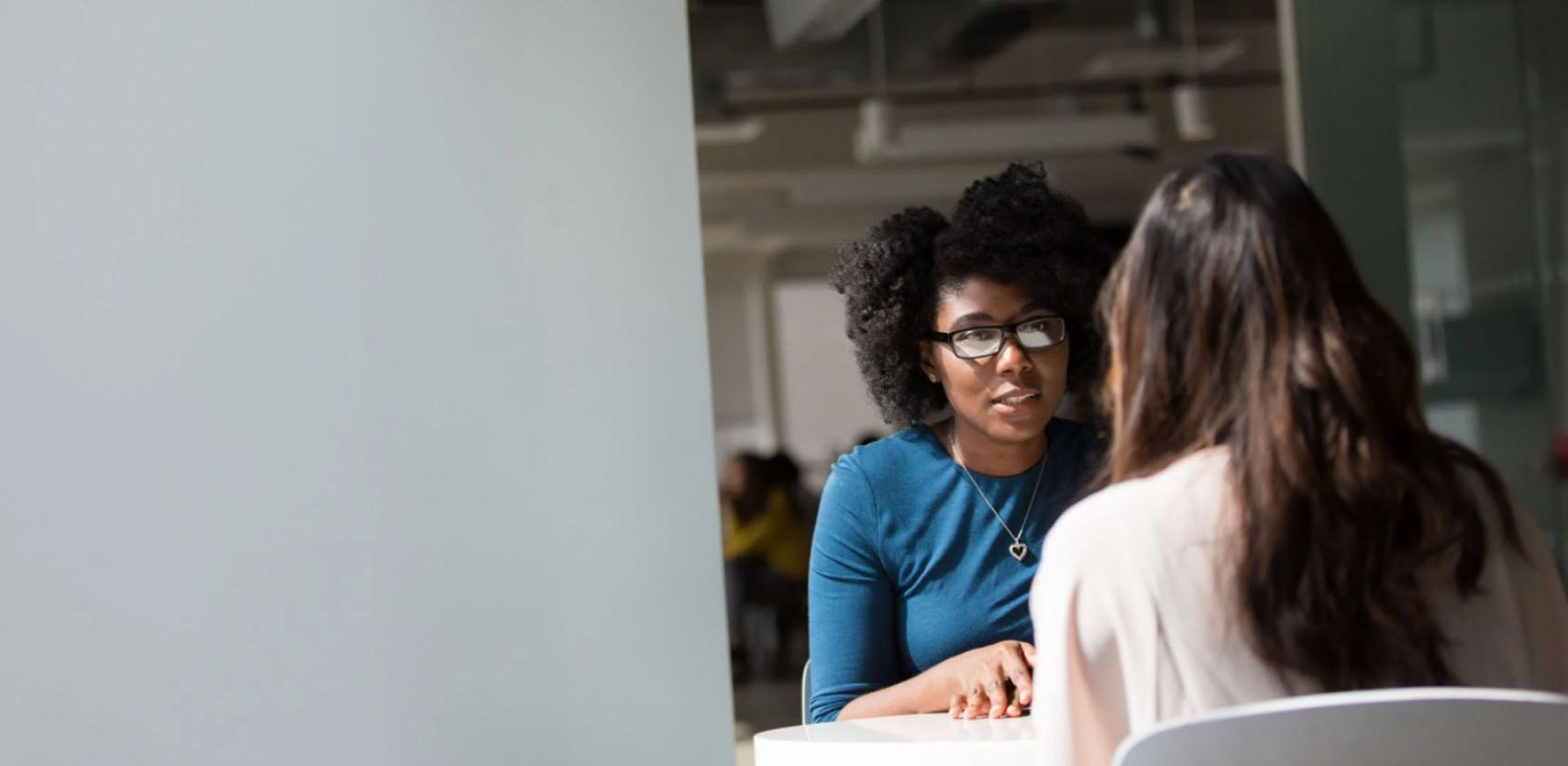 two people sitting at a table having a conversation