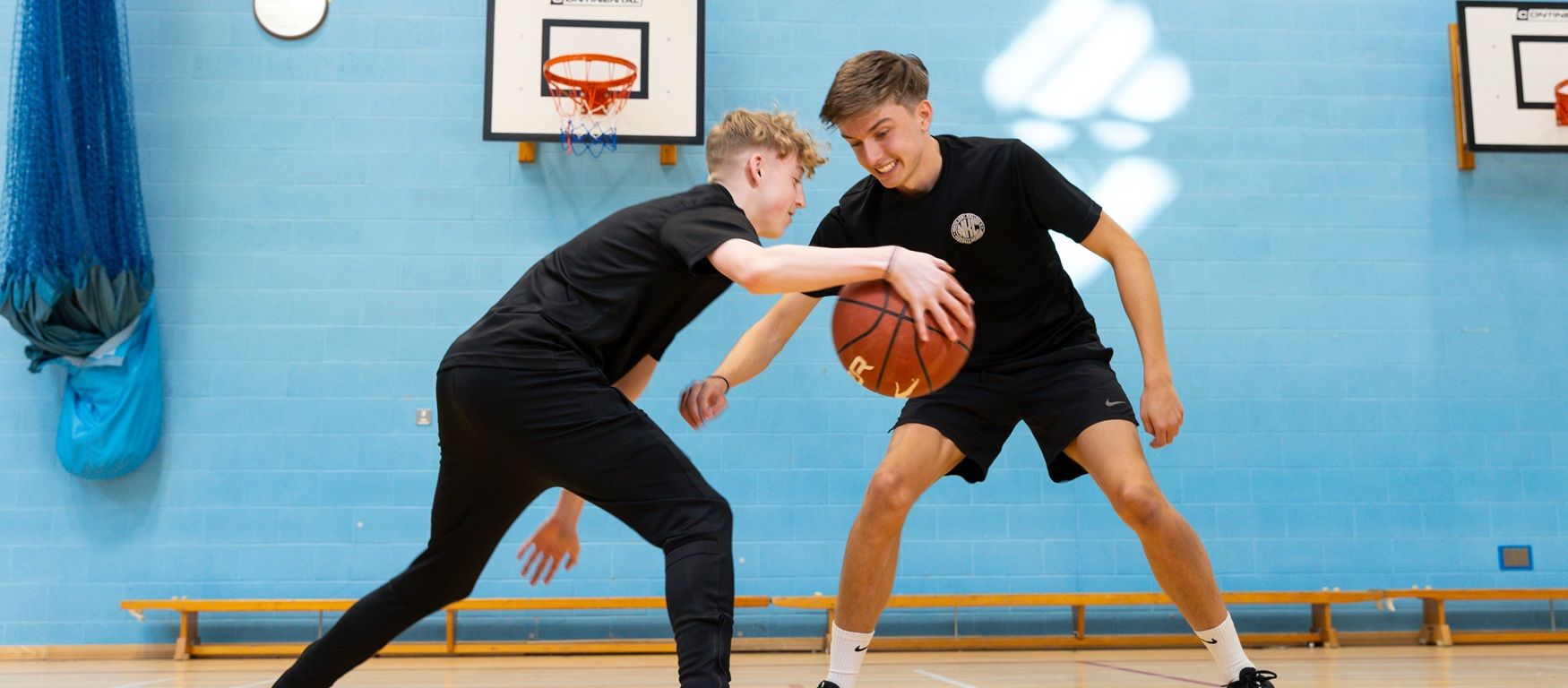 Two students playing basketball
