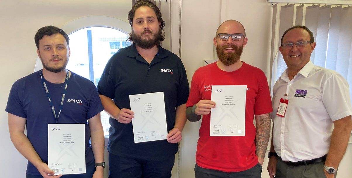 Three students holding certificates, along with tutor