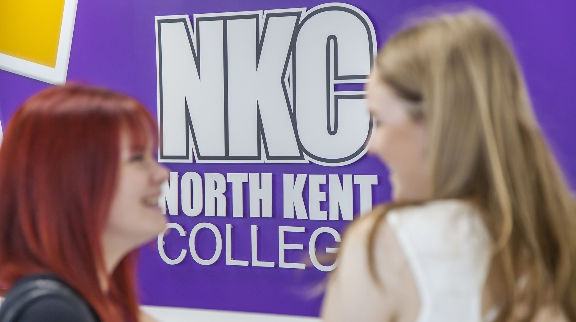 Students standing in front of NKC sign