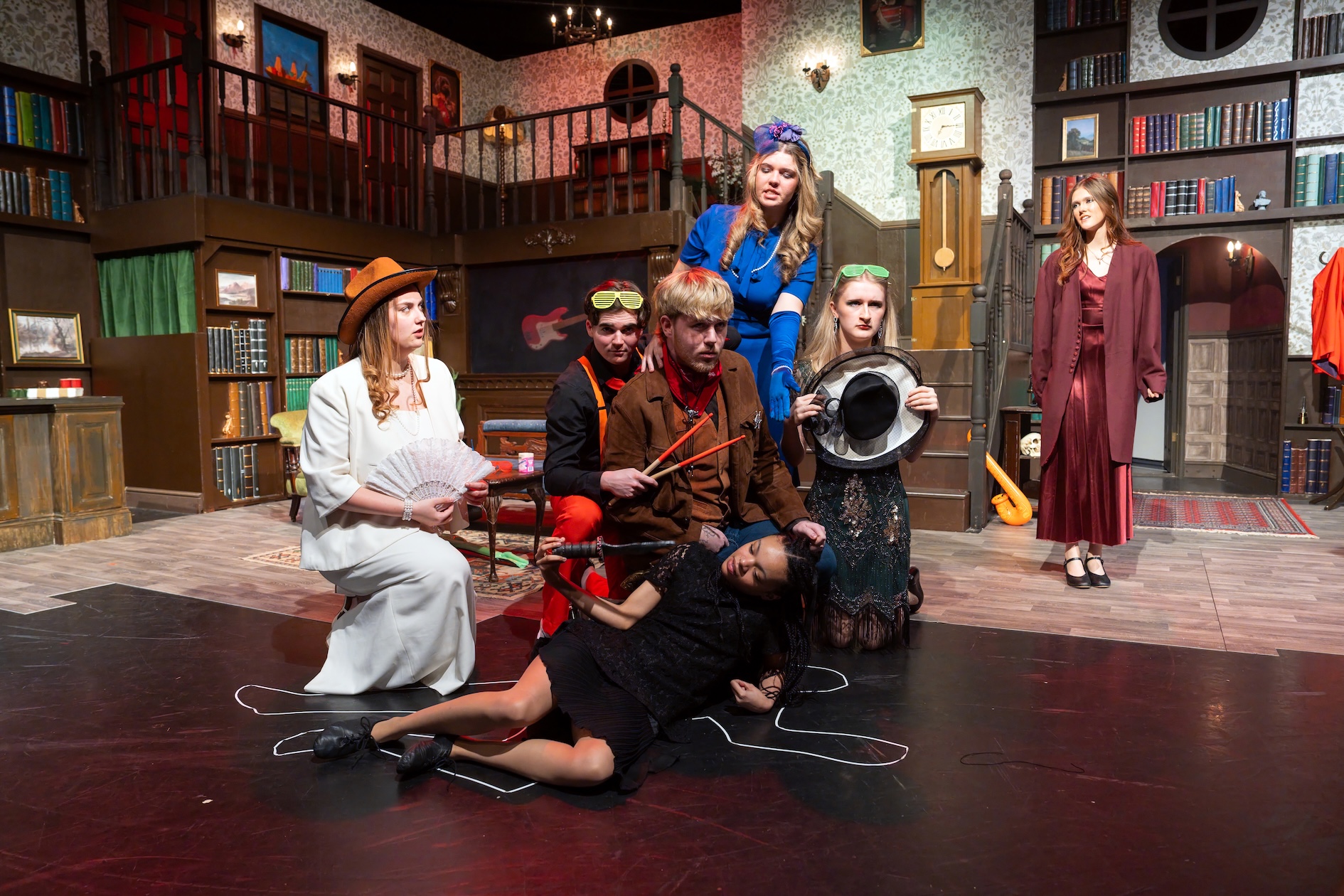 Students actors on a stage in a scene depicting a murder
