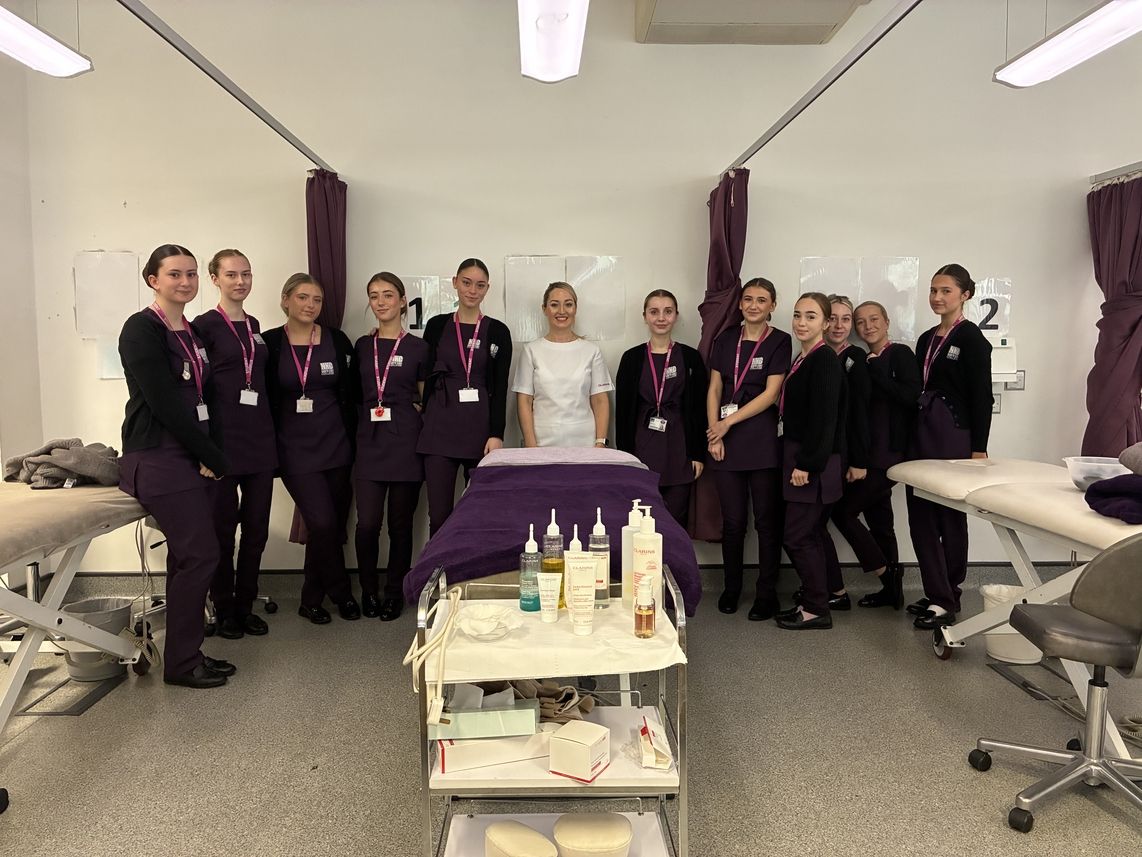 students standing round beauty table with guest in middle