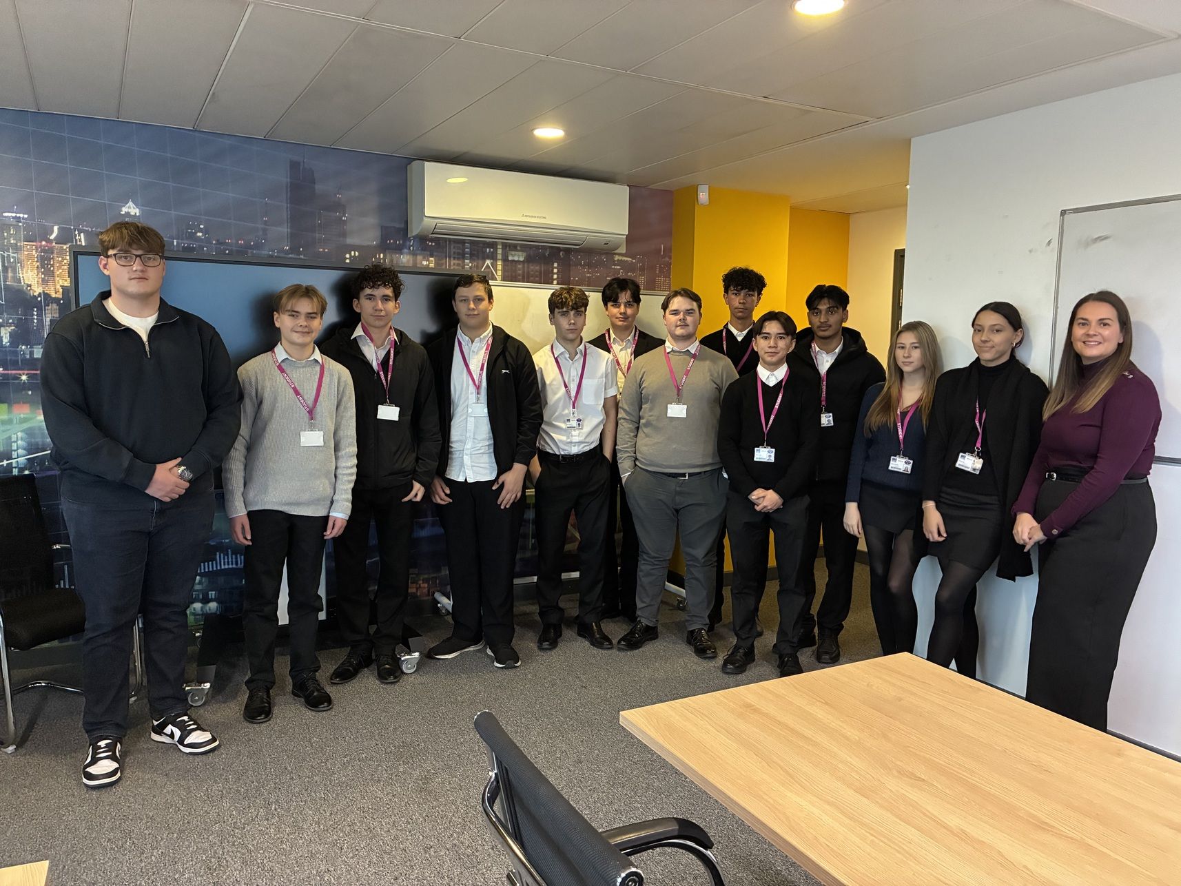 Students standing in a line with man guest speaker on the left and female speaker on the right