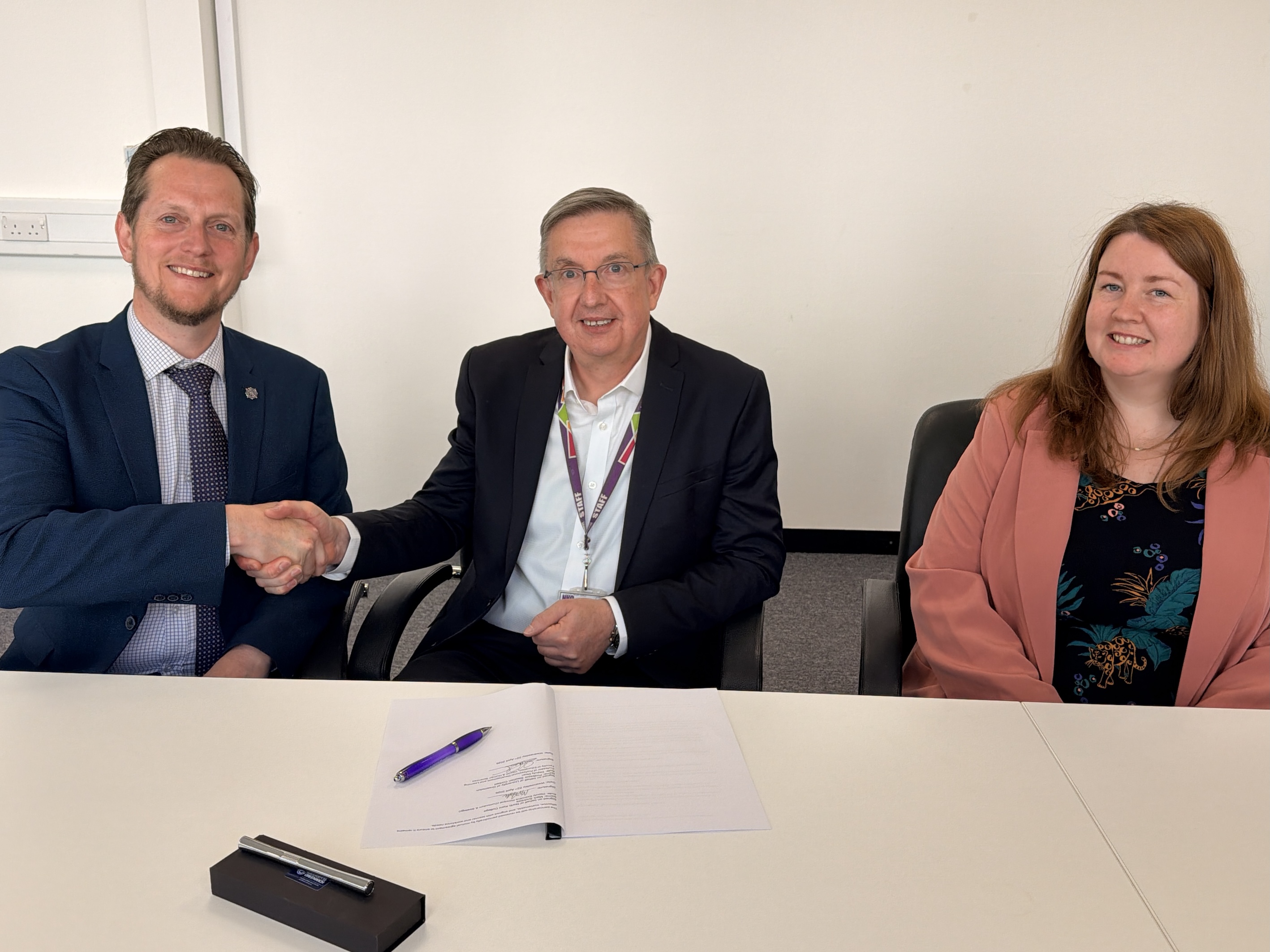Three people from the University of Greenwich and North Kent College sitting at a table